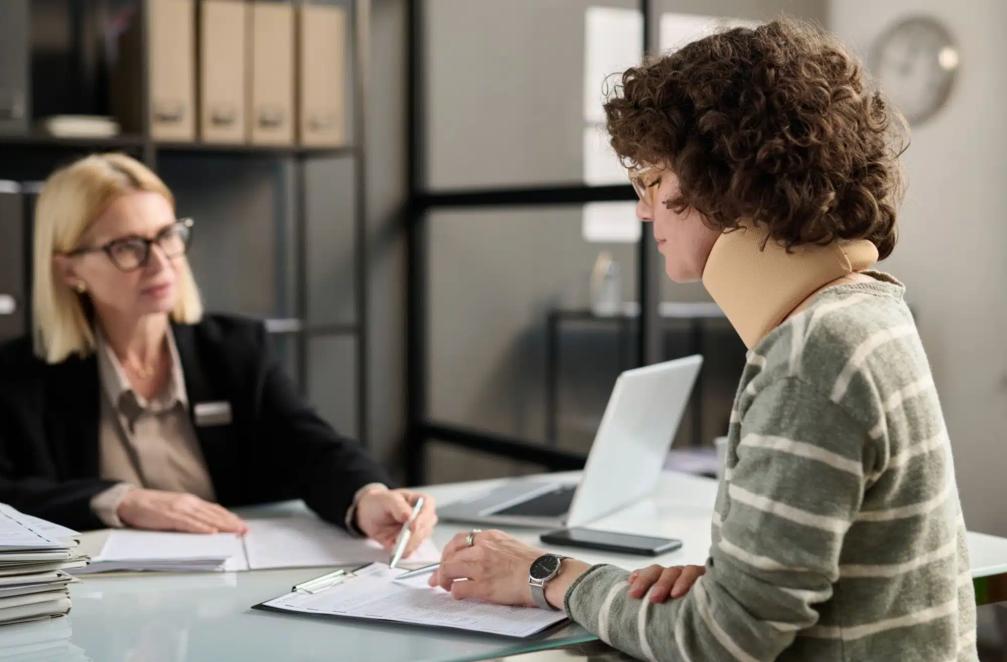 Young woman in a neck brace filing documents